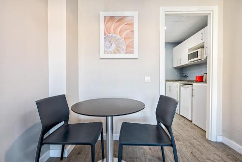 a dining room with a table and two chairs at Veramar Aparthotel in Fuengirola