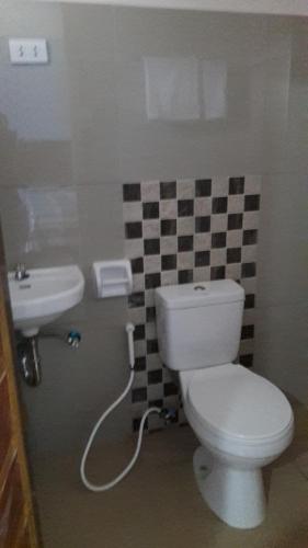 a bathroom with a toilet and a sink at Mayon Lodging House in Legazpi
