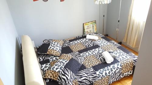 a bed with a black and white comforter and pillows at Apartment Nano in Šibenik