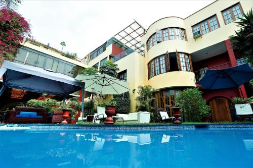 a hotel with a swimming pool in front of a building at Peru Star Apart-Hotel in Lima