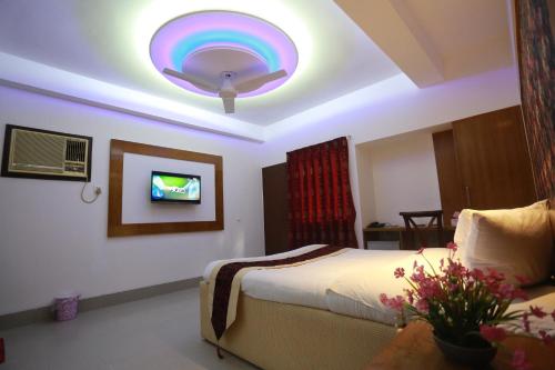 a bedroom with a bed with a rainbow ceiling at Nagar Valley Hotel Ltd. in Dhaka