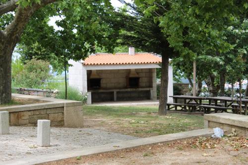 a picnic shelter in a park with benches and trees at Hotel Medieval® de Penedono in Penedono