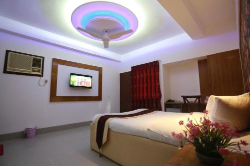 a bedroom with a bed and a tv on the wall at Nagar Valley Hotel Ltd. in Dhaka