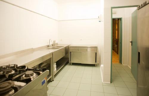 uma cozinha com um lavatório e um fogão em Ostello Fontemaggio em Assis
