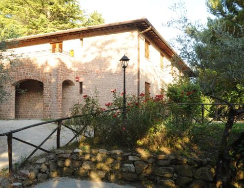 ein Backsteingebäude mit einem Zaun und einer Straßenbeleuchtung in der Unterkunft Ostello Fontemaggio in Assisi