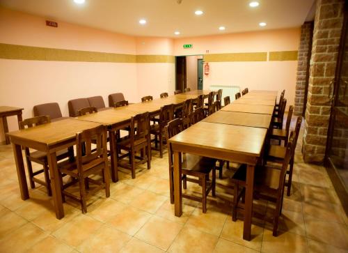 a row of wooden tables and chairs in a room at Ostello Fontemaggio in Assisi