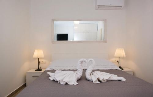 a bedroom with a bed with white socks and a window at Luxury villa Vela Rina in Mali Drvenik