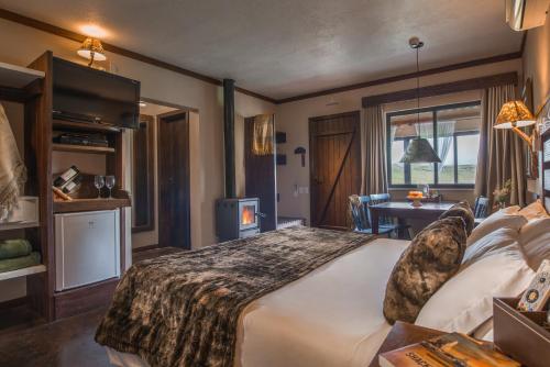 une chambre avec un grand lit et un bureau dans l'établissement Rio do Rastro Eco Resort, à Bom Jardim da Serra