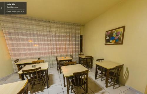 ein Klassenzimmer mit Tischen, Stühlen und einem Fenster in der Unterkunft Hotel Joia in Cascavel