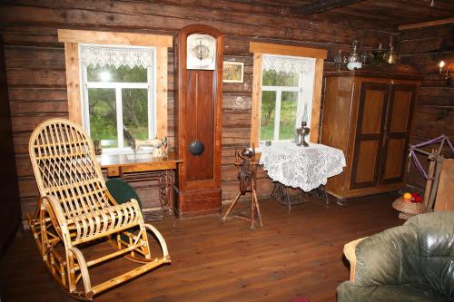 una stanza con una sedia e un tavolo in una cabina di Ethnographic holiday house LAIPAS a Murjāņi
