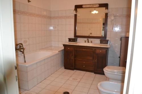 La salle de bains est pourvue d'une baignoire, d'un lavabo et de toilettes. dans l'établissement Bed and Breakfast Via Della Piazza, à Pescasseroli