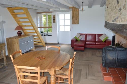 a living room with a table and chairs and a couch at Aux Volets Bleus Chez Mark & Sylvie in Rouffignac Saint-Cernin
