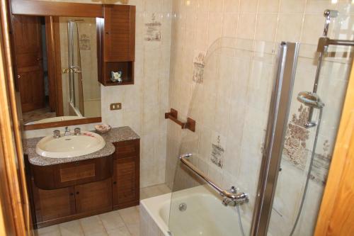 a bathroom with a shower and a sink and a tub at Villa La Favola in Ischia