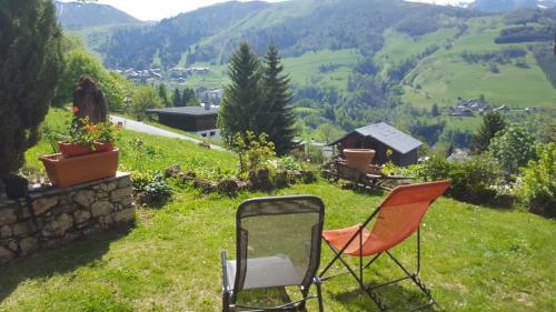 two chairs sitting in the grass on a hill at Chalet la Ravine in Valmorel