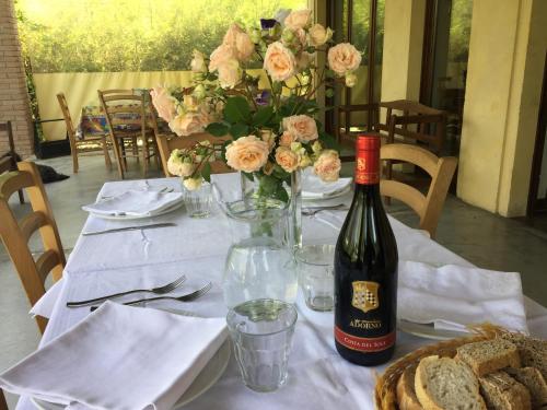 a table with a bottle of wine and a vase of flowers at Agriturismo Spizzirò in Ponte Nizza