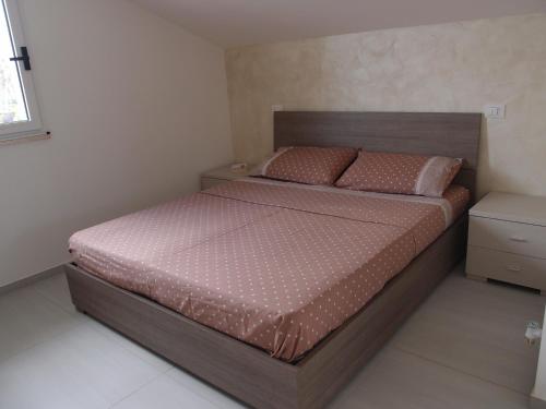 ラグーザにあるSulle tracce di Montalbano Loftのベッドルーム1室(大型ベッド1台、木製ヘッドボード付)