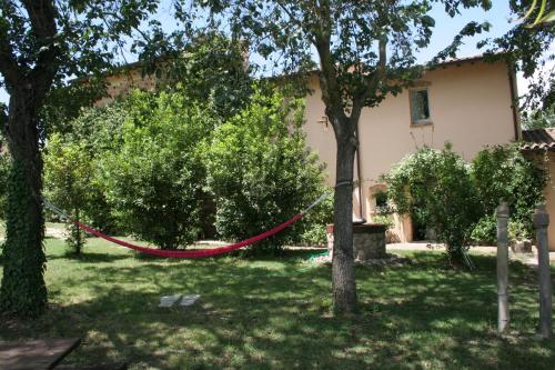a yard with a red hammock in front of a house at La Fratta Art - House in Marsciano