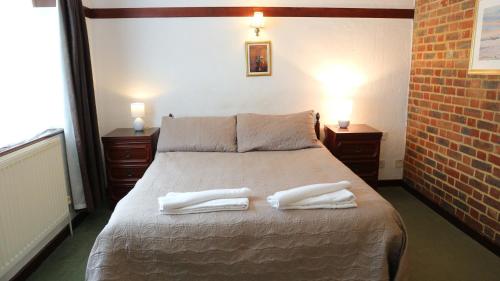 A bed or beds in a room at Harrow Inn 