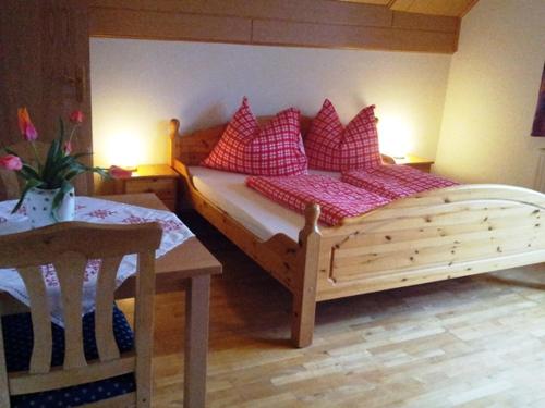 a bedroom with a wooden bed with red pillows at Lindlhof Fam. Taferner in Sankt Andrä
