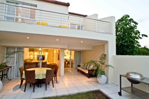 une terrasse avec une table et des chaises dans une maison dans l'établissement D3 Sea Lodge - by Stay in Umhlanga, à Durban