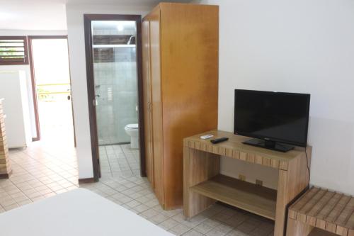 a living room with a television on a table at Marambaia Apart Hotel in Natal