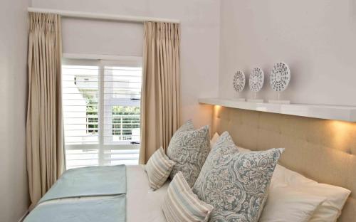 a bedroom with a bed with pillows and a window at D3 Sea Lodge - by Stay in Umhlanga in Durban
