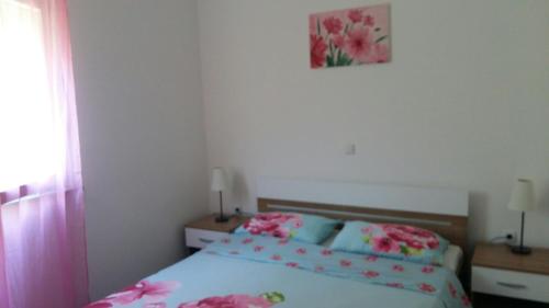 a bedroom with a bed with pink flowers on it at House Lavanda in Rab