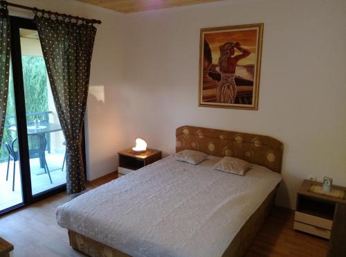 una camera con un letto e una foto appesa al muro di River House Buna a Mostar