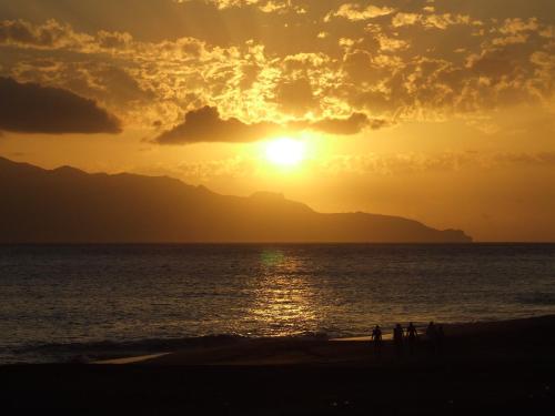 people walking on the beach at sunset at Hotel Ocean View & Restaurante Seafood in São Filipe