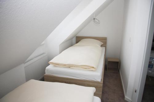 a attic room with two beds and a staircase at To Eek in Tinnum