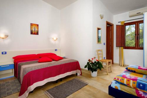 a bedroom with a bed with red pillows on it at Casa Museddu in Cardedu