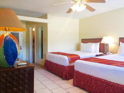 a hotel room with two beds and a ceiling fan at Bolongo Bay Beach Resort in Bolongo