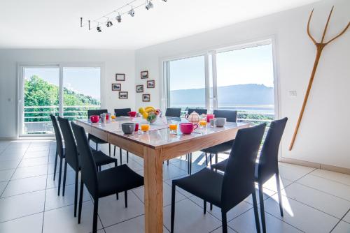 une salle à manger avec une grande table et des chaises en bois dans l'établissement Gîte LaurieRaphael, à Pugny-Chatenod