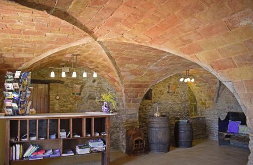 Pokój z ceglaną ścianą i półką z beczkami z winem w obiekcie Masia Ca La Caputxeta & Golf w mieście Castelló d'Empúries