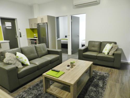 a living room filled with furniture and a coffee table at Motel 24 in Wodonga