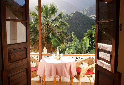 a table on a balcony with a view of a mountain at Casa Creativa in Hermigua
