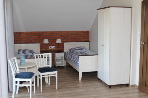 a small bedroom with a bed and a table and chairs at Dom Mierzeja in Kąty Rybackie