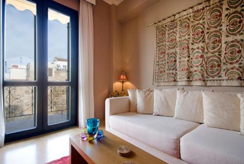 a living room with a white couch and a large window at Spolia Art Maison in Chania Town