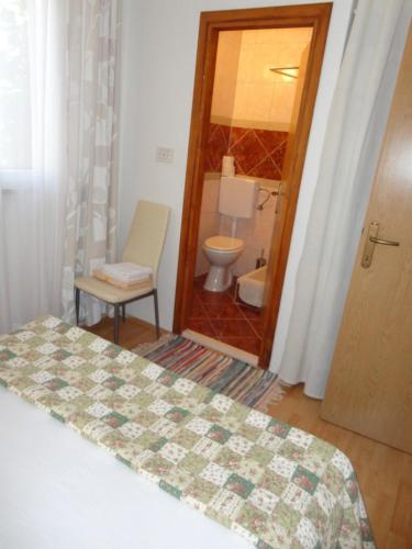 a bedroom with a bed and a bathroom with a toilet at Apartment Villa Green Court in Korčula