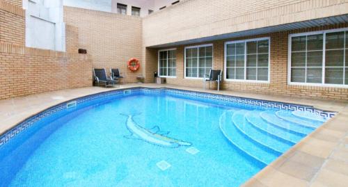 a swimming pool with a shark in the water at Aparthotel Los Girasoles in Zaragoza