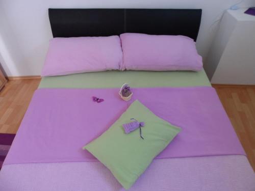- un lit avec des draps violets et verts et une étoile dans l'établissement Apartments Dalia House, à Hvar
