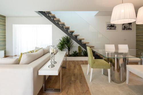 a living room with a white couch and a glass table at Gallo`s House in Barcelos