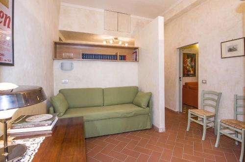un soggiorno con divano verde e tavolo di Appartamento Matteotti a Volterra