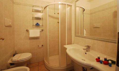 a bathroom with a shower and a toilet and a sink at Hotel Sporting in Alba Adriatica