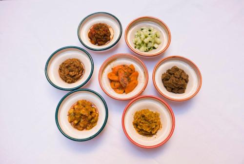a group of four bowls filled with different types of food at Medina social club in Fès