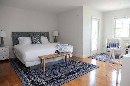 a bedroom with a bed and a table on a rug at The Sea Breeze Inn in Middletown