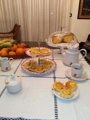 a table with plates of food and cups and a cake at B&B Su Canistreddu in Alghero