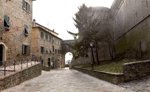 an alley in an old stone building with a tree at Appartamento Matteotti in Volterra