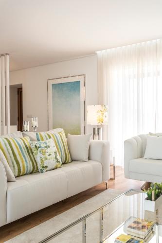 a living room with a white couch and a table at Gallo`s House in Barcelos