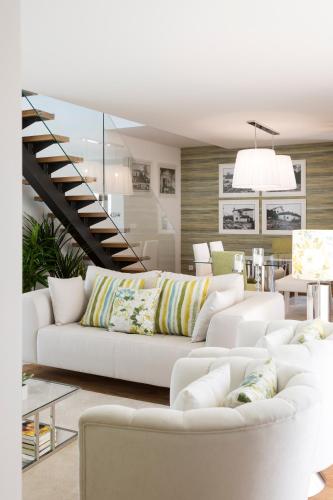 a living room with white couches and a staircase at Gallo`s House in Barcelos